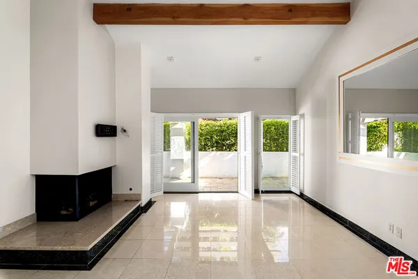 a view of an empty room with a fireplace and a window