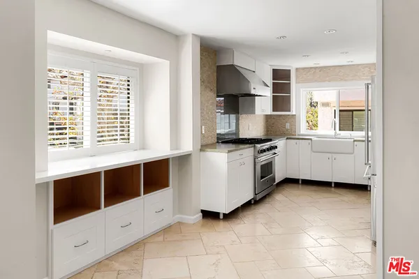 a kitchen with a stove and white cabinets