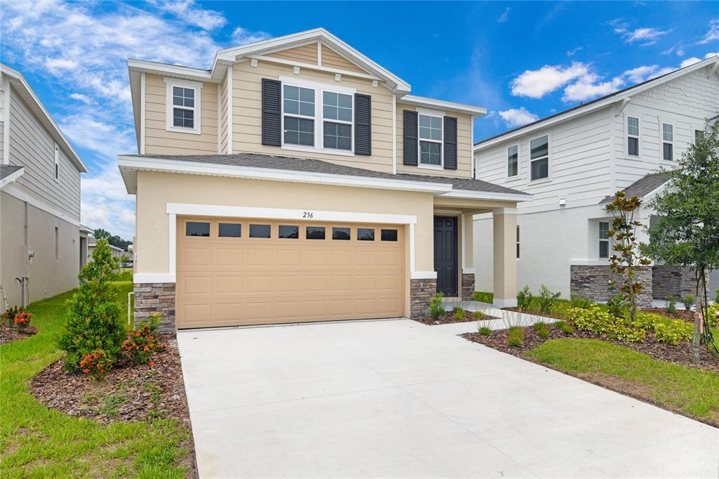 236 Flag Lilly Lane Umatilla, FL 32784 - Photo 2 of 25 a front view of a house with a yard and garage