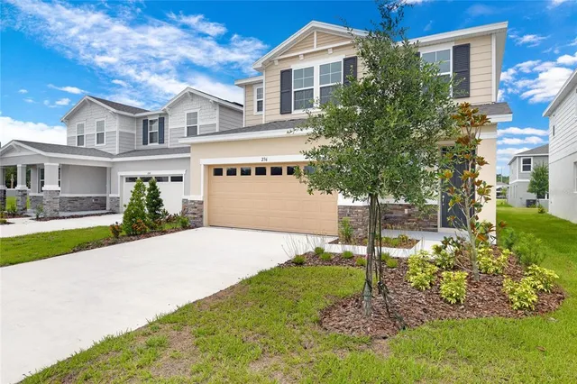 a front view of a house with a yard and trees
