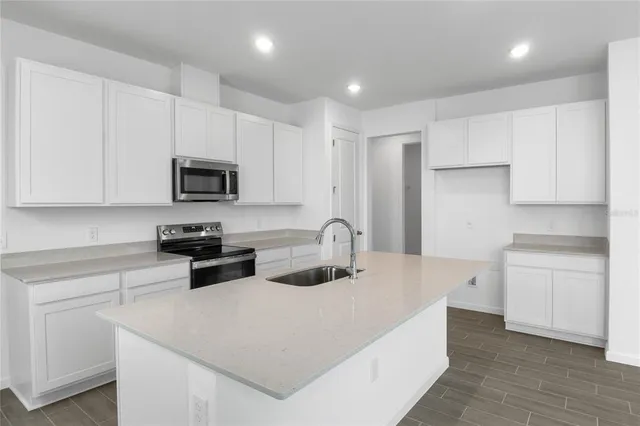 a kitchen with stainless steel appliances a microwave sink refrigerator and cabinets