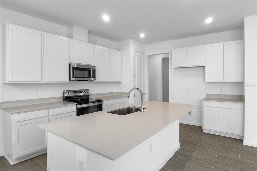 236 Flag Lilly Lane Umatilla, FL 32784 - Photo 7 of 25 a kitchen with stainless steel appliances a microwave sink refrigerator and cabinets
