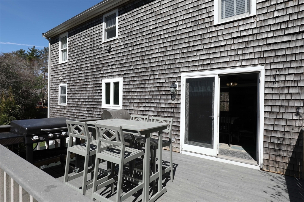 40 Pine Street Carver, MA 02330 - Photo 20 of 30 a view of a patio with table and chairs with wooden floor and fence