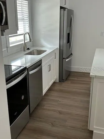 a kitchen with stainless steel appliances granite countertop a refrigerator and a sink
