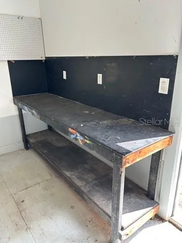 a view of an empty room and chandelier fan