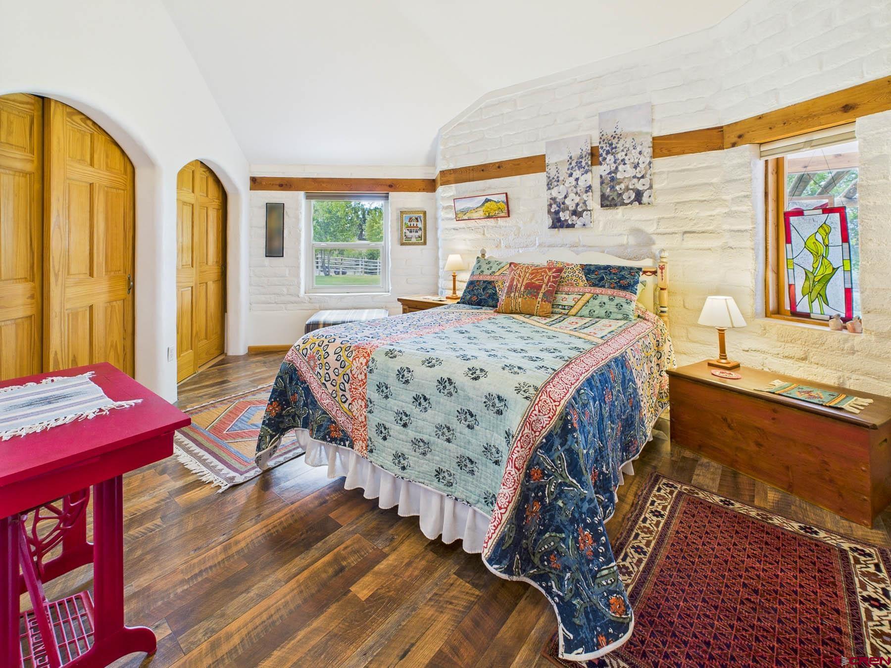 19550 2325th Road Cedaredge, CO 81413 - Photo 21 of 45 a bedroom with a bed and a dresser next to a window