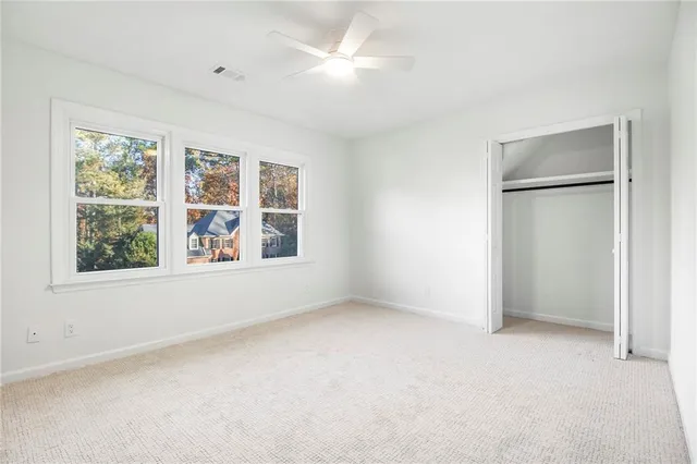 an empty room with windows and closet