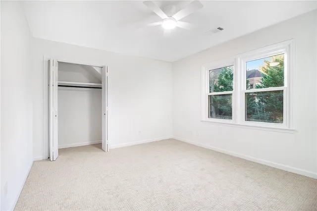 an empty room with windows and closet