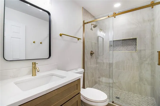 a bathroom with a sink a toilet and shower