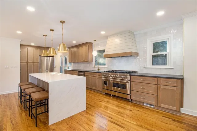 a kitchen with kitchen island a counter top space appliances and cabinets