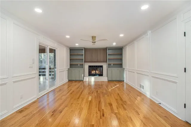 a view of a livingroom with wooden floor and a fireplace