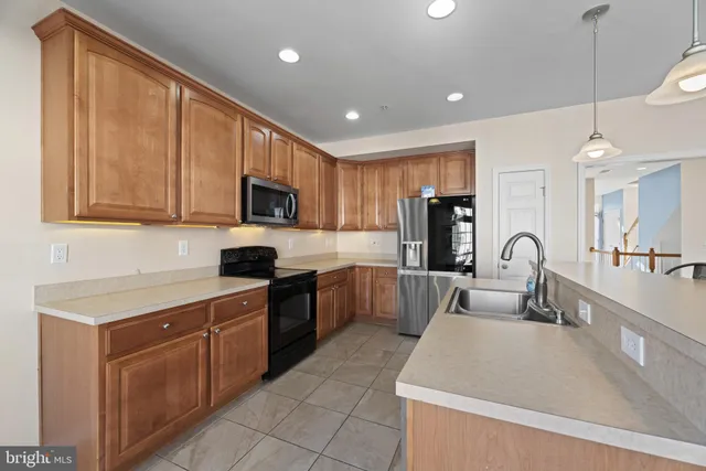 a kitchen with stainless steel appliances granite countertop a sink counter space cabinets and a large window