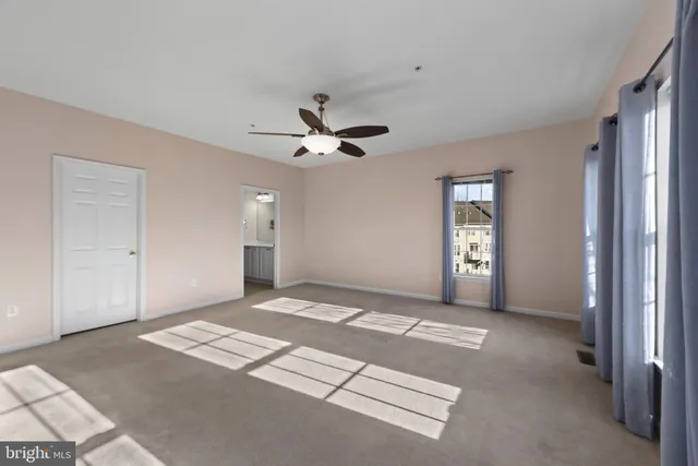a view of a livingroom with a ceiling fan and window