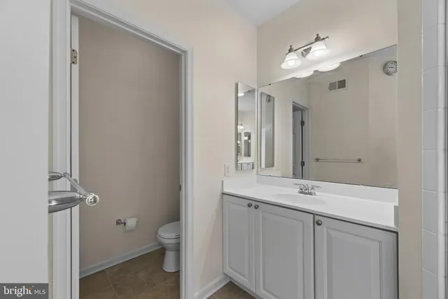 a bathroom with a toilet a sink a mirror and vanity