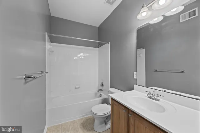 a bathroom with a sink a toilet a tub and shower