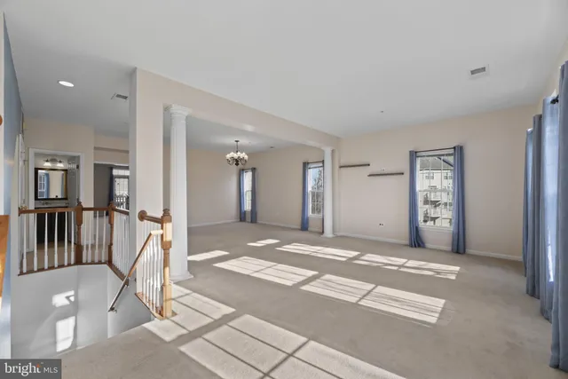 a view of a hallway with wooden floor and a living room