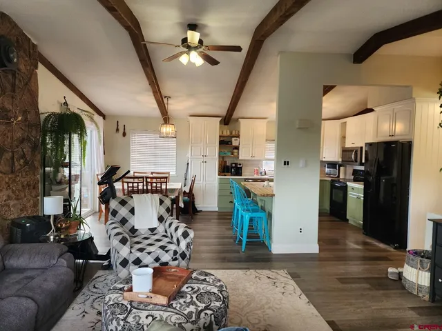 a kitchen with a refrigerator a stove a sink dishwasher with a dining table and chairs