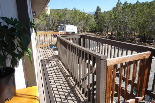a view of balcony with wooden floor and fence