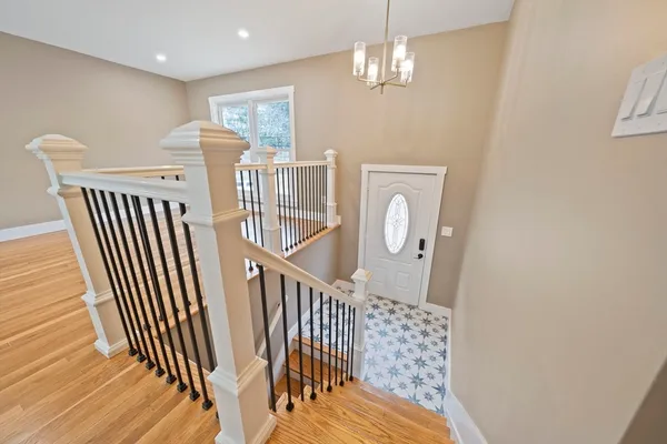 a view of a hallway with windows and chandelier