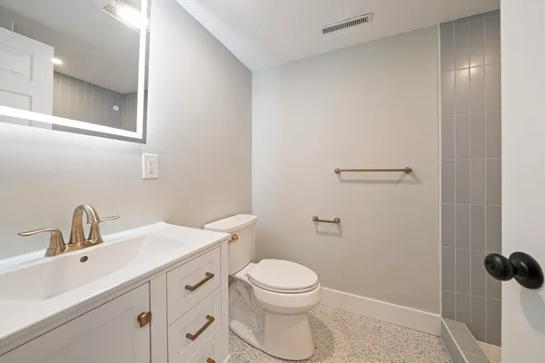 a bathroom with a sink a toilet and a mirror