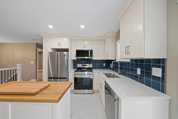 a kitchen with stainless steel appliances a refrigerator sink and microwave