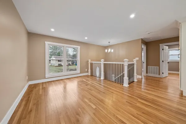 a view of a big room with wooden floor and windows