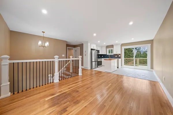 a view of a room with wooden floor stairs and windows