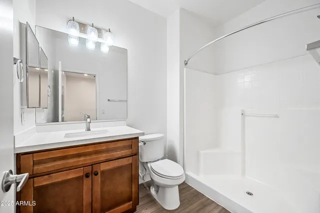 a bathroom with a sink a toilet and shower