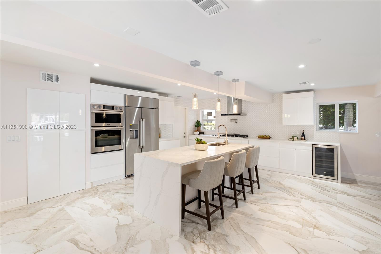 721 Southwest 15th Street Boca Raton, FL 33486 - Photo 17 of 46 a kitchen with stainless steel appliances kitchen island granite countertop a refrigerator and cabinets