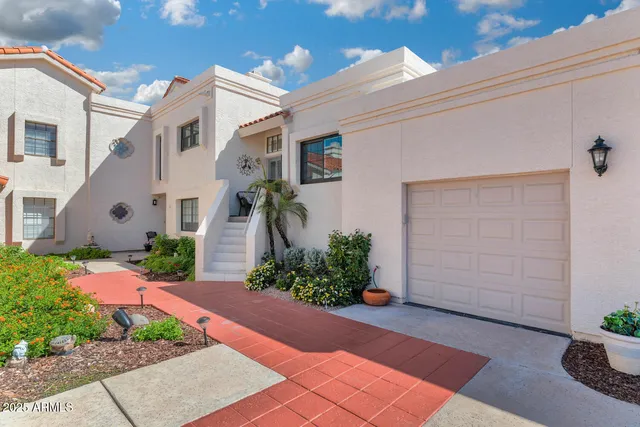 a front view of a house with potted plants