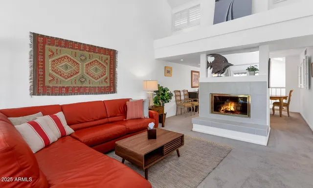 a living room with furniture a fireplace and a wall painting