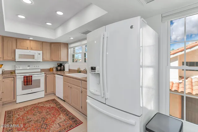 a kitchen with white cabinets and white appliances