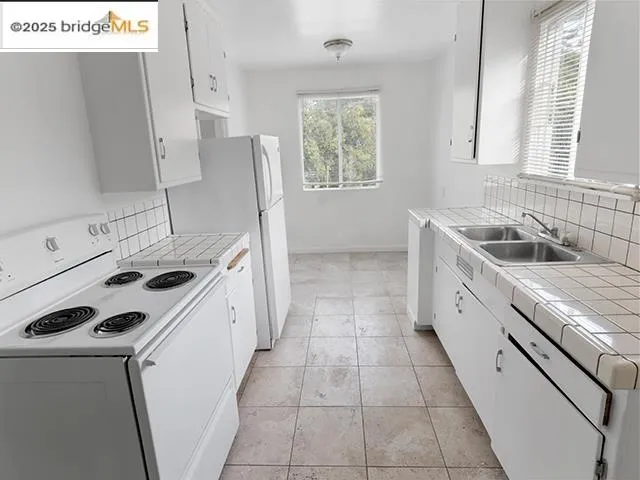 a kitchen with a sink stove top oven and cabinets