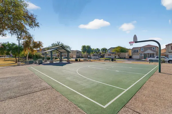 a view of a tennis ground with large trees