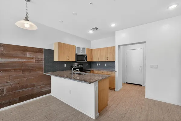 a kitchen with sink refrigerator and microwave