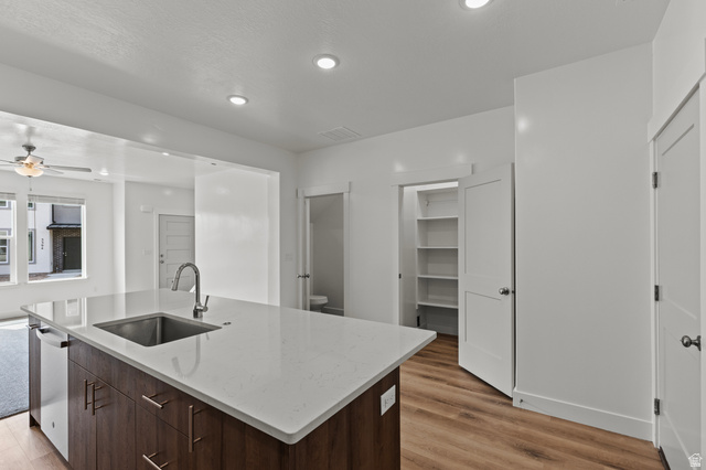 3410 South 1010th Street West Logan, UT 84321 - Photo 4 of 15 Kitchen with dark brown cabinets, light stone countertops, a kitchen island with sink, recessed lighting, and light wood-type flooring