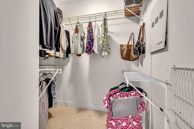 a view of walk in closet with clothes and shoes