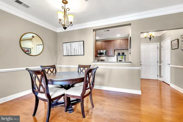 a view of a dining room with furniture a chandelier and wooden floor