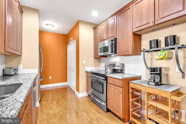 a kitchen with stainless steel appliances granite countertop a stove a sink and a refrigerator