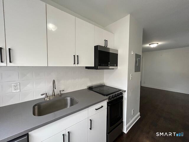 114 Grove Street, Unit 12 Stamford, CT 06901 - Photo 13 of 13 a kitchen with a sink a microwave a refrigerator and cabinets