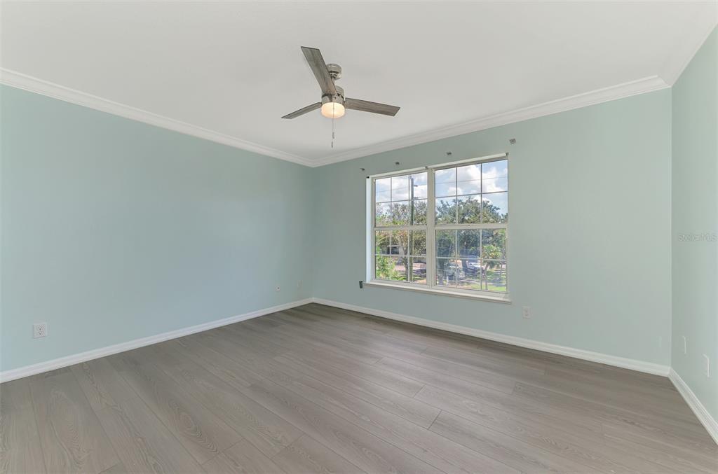 1380 Beach Road, Unit 4 Englewood, FL 34223 - Photo 32 of 47 an empty room with wooden floor fan and windows