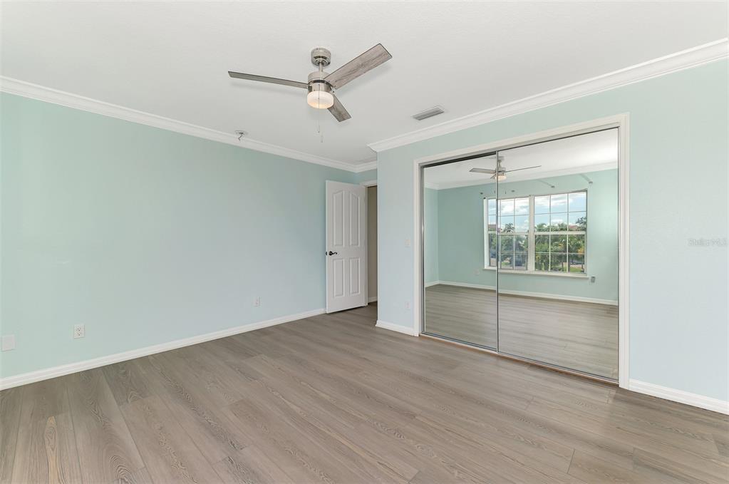 1380 Beach Road, Unit 4 Englewood, FL 34223 - Photo 33 of 47 an empty room with wooden floor fan and windows