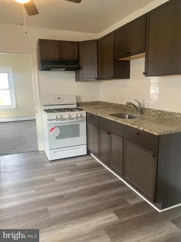 a kitchen with granite countertop a sink and a stove top oven