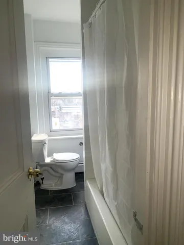 a bathroom with a toilet and a bathtub