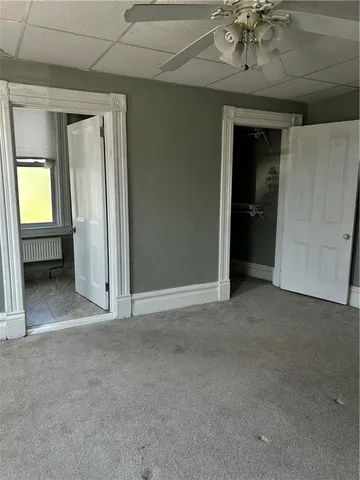 an empty room with a mirror and a fan