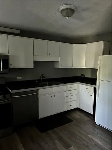 a kitchen with granite countertop white cabinets and black appliances