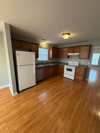 a kitchen with stainless steel appliances granite countertop a refrigerator a stove and a wooden floors