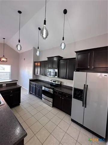 a kitchen with stainless steel appliances granite countertop a sink a stove and a refrigerator