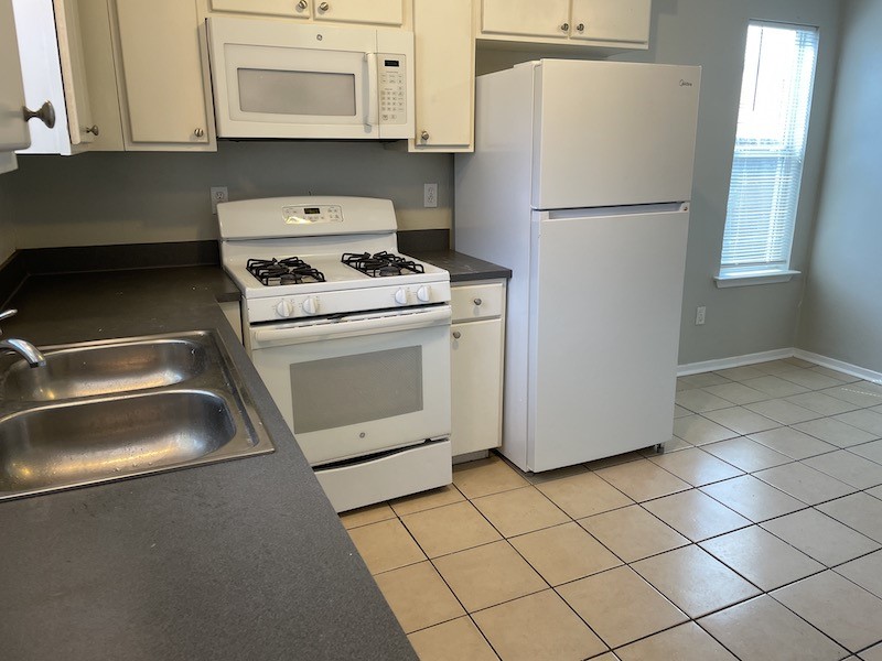 8401 Colony Loop Drive, Unit D Austin, TX 78724 - Photo 5 of 18 a white refrigerator freezer and a stove sitting inside of a kitchen