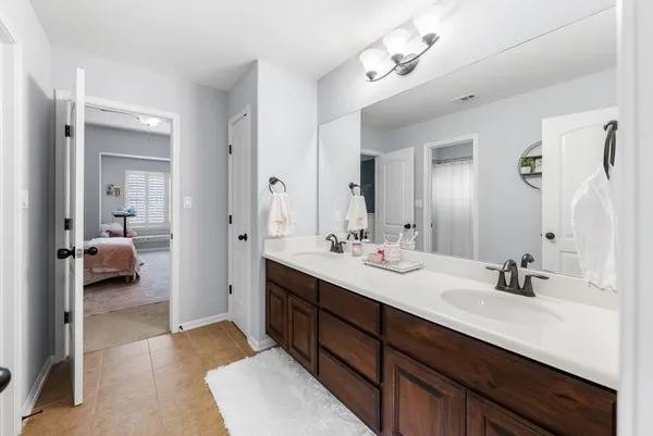 a en suite bathroom with a double vanity sink and a mirror